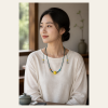 Golden Orb Cord Necklace — young East Asian woman styling view